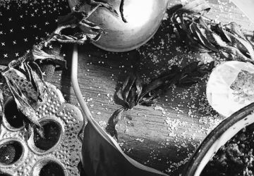 a black and white image of a bowl, salt, and herbs